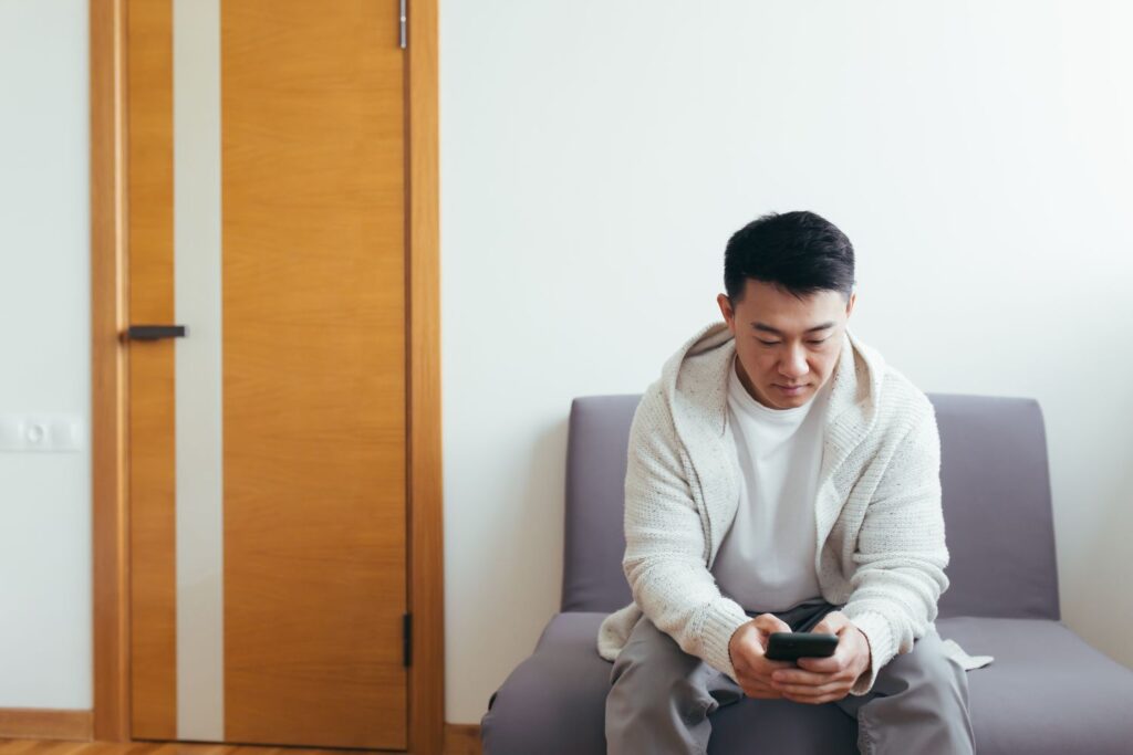 A young man is waiting in the hallway of a clinic or office center